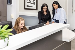 Three nurses at the nurses' station at the San Joaquin Nursing and Rehab facility